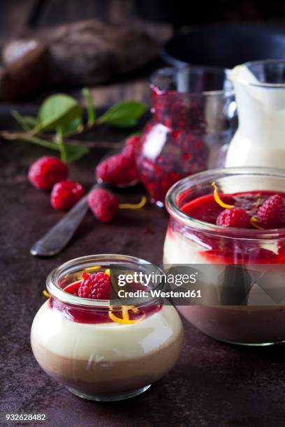 glasses of pudding with vanilla sauce and raspberry sauce garnished with raspberries and orange zest - raspberry coulis stock pictures, royalty-free photos & images