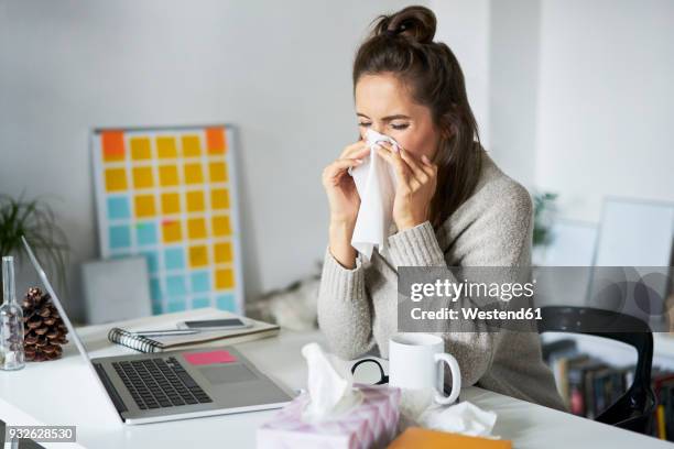 ill woman at home at desk blowing her nose - snyta sig bildbanksfoton och bilder