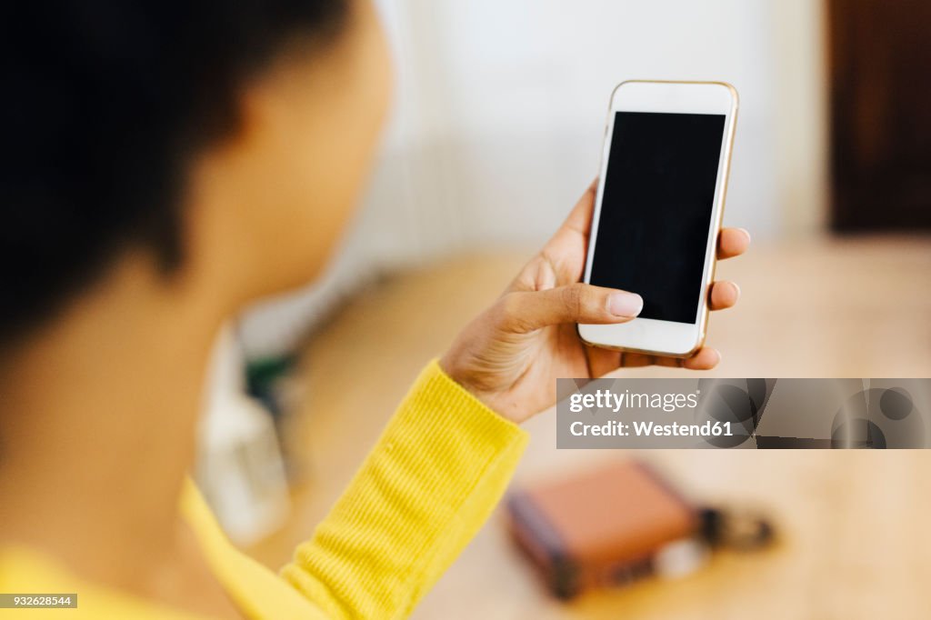 Young woman at home using smartphone