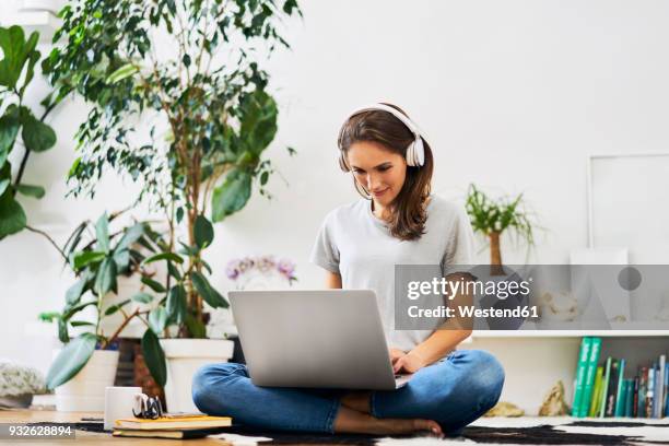 young woman at home sitting on the floor using laptop and listening to music - students computer imagens e fotografias de stock