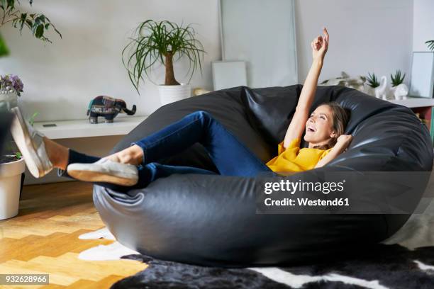 happy young woman relaxing at home in beanbag - bean bags stock pictures, royalty-free photos & images