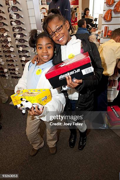 Happy children pose for a photo while showing off their new shoes at Payless ShoeSource on November 20, 2009 in Cincinnati, Ohio.