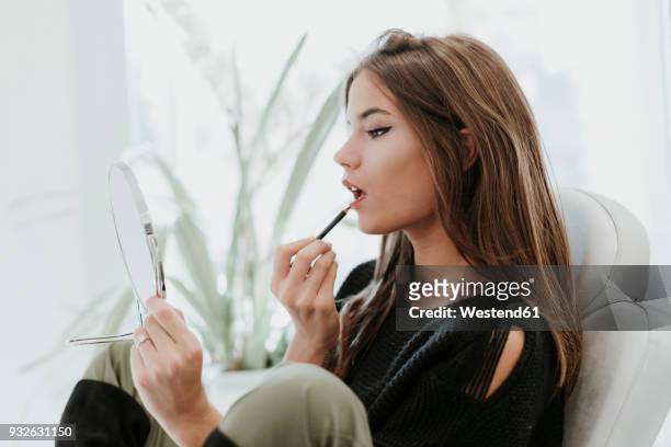 portrait of young woman using lip pencil - konturstift stock-fotos und bilder