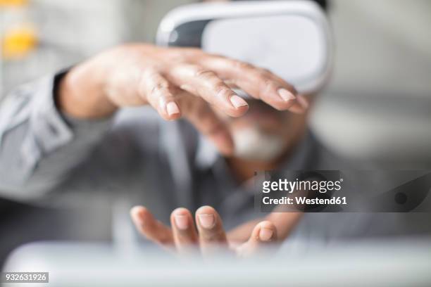 man shaping with his hands wearing vr glasses in office - dare la forma foto e immagini stock