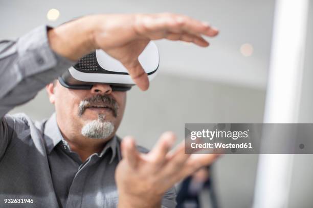 man shaping with his hands wearing vr glasses in office - shaping future stock-fotos und bilder