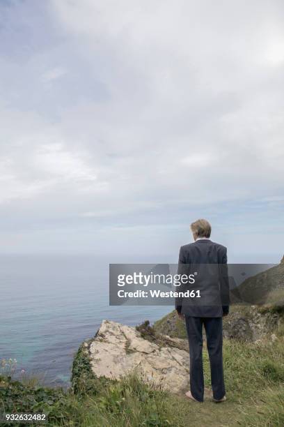 uk, cornwall, gwithian, businessman standing at the coast looking at view - gwithian ストックフォトと画像
