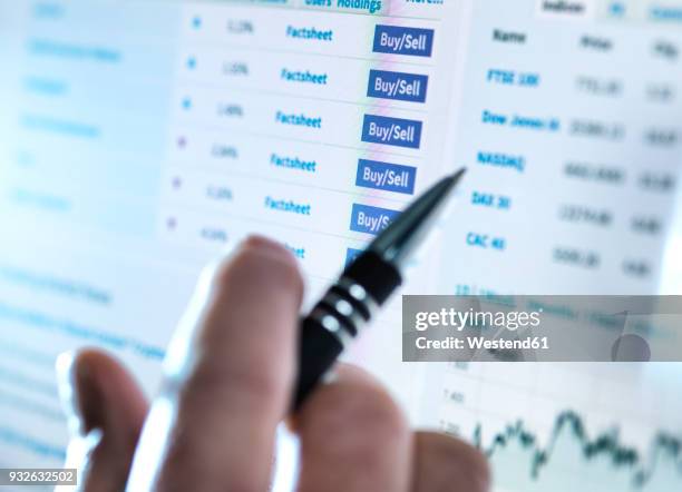 hand of a stockbroker buying and selling shares online - certificado de una acción fotografías e imágenes de stock