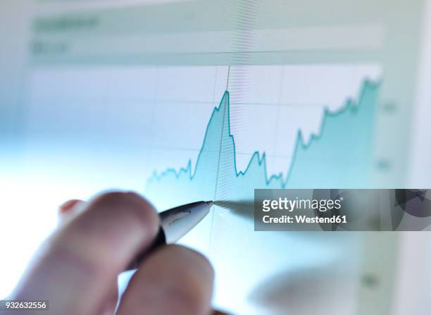 hand of a stock broker analysing line graph on computer screen - scrutiny foto e immagini stock