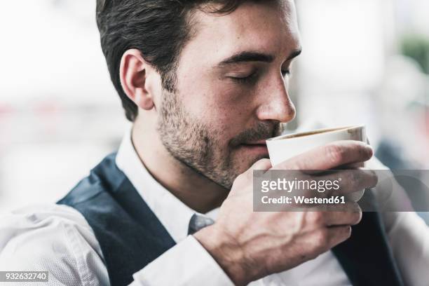 relaxed young man drinking cup of coffee - kaffee genießen stock-fotos und bilder