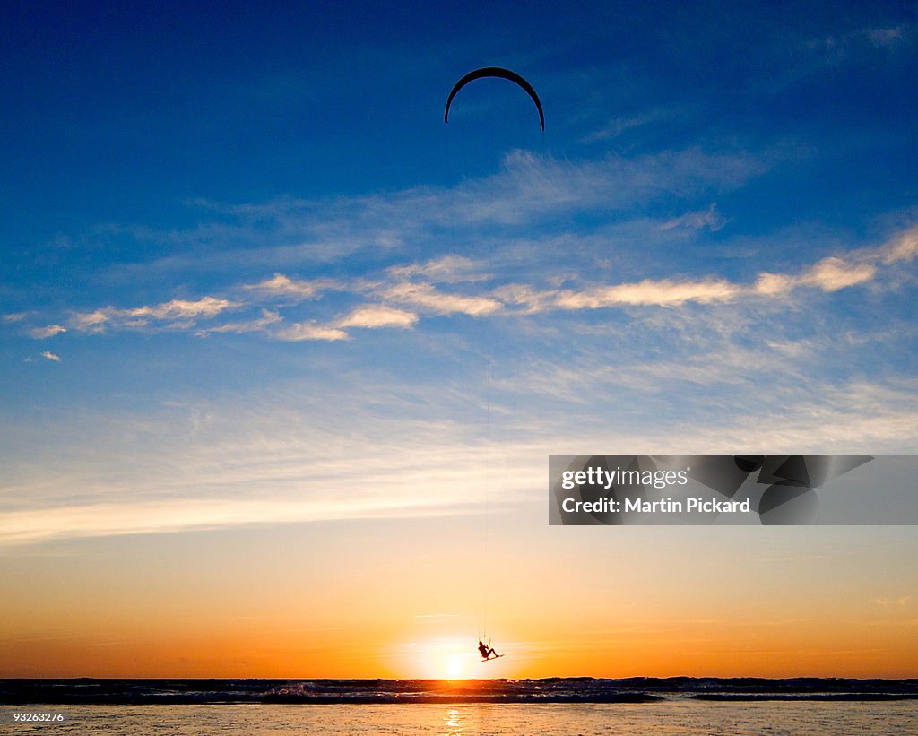 Kite surfer jumps the sunset