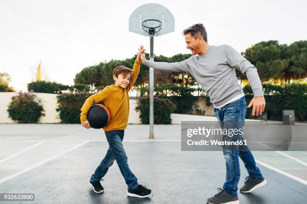 father and son high fiving on basketball outdoor court - day 10 imagens e fotografias de stock