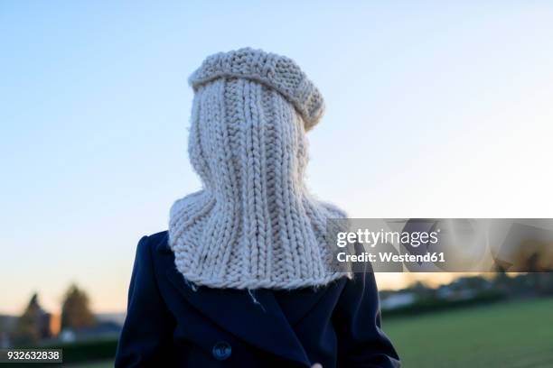 boy covering his face with knitted round scarf - shawl collar stock-fotos und bilder