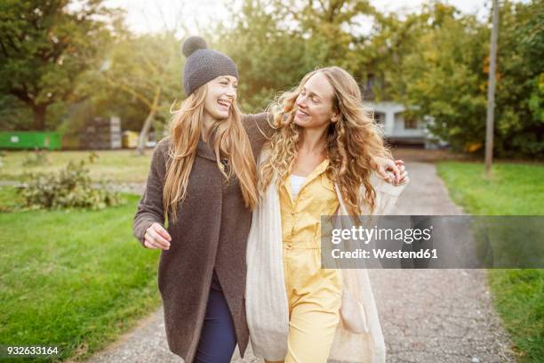 two happy women walking in rural landscape - the girlfriend stock-fotos und bilder