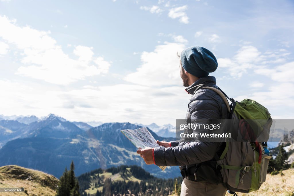 Austria, Tyrol, young man with map in mountainscape