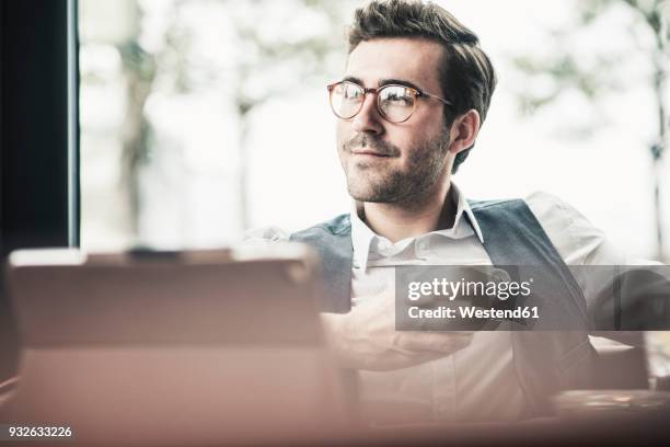 smiling young man in a cafe with tablet and cup of coffee - casual businessman glasses white shirt stock pictures, royalty-free photos & images