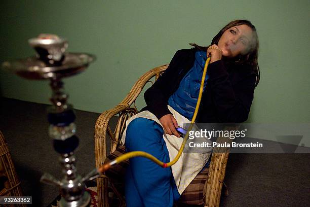 Afghan actress Trena Amiri smokes a water pipe relaxing after the end of the day of shooting the soap opera "Love and Old Age" November 20, 2009 in...