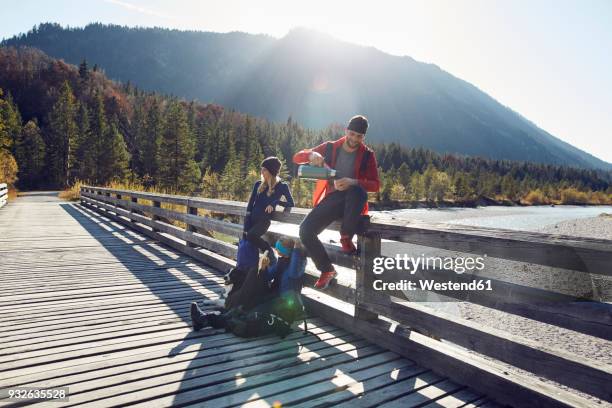 group of friends with dog hiking resting on a bridge - hiking across the karwendel mountain range stock pictures, royalty-free photos & images