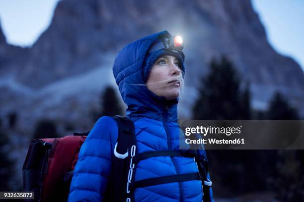 young woman wearing headlamp at dusk in the mountains - hoofdlamp stockfoto's en -beelden