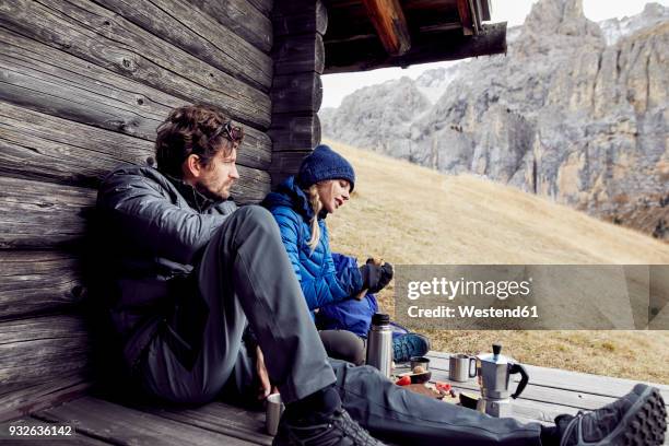 couple having a break at mountain hut - berghütte stock-fotos und bilder