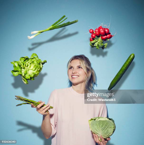 portrait of happy young woman juggling with vegetables - blattgemüse stock-fotos und bilder