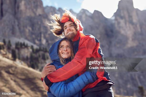 happy young couple hugging in windy mountains - hair love stock pictures, royalty-free photos & images