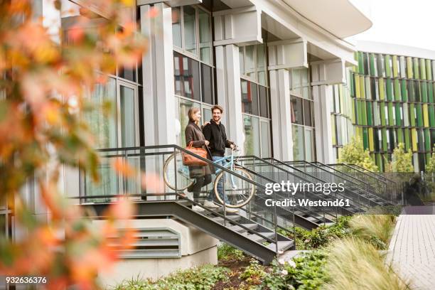 smiling couple leaving house with bicycles - germany city stock pictures, royalty-free photos & images