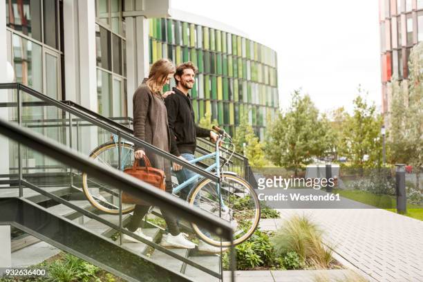 Smiling couple leaving house with bicycles