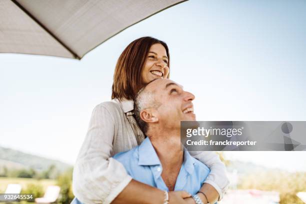 happiness couple piggyback - mid adult couple stock pictures, royalty-free photos & images