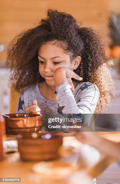 displeased african american girl doesn't want to eat her breakfast. - picky eater stock pictures, royalty-free photos & images