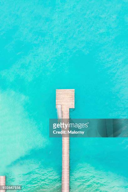 bird's eye view, aerial view or drone view of a wooden jetty or pier. turquoise water. - bahamas aerial stockfoto's en -beelden