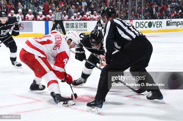 Anze Kopitar of the Los Angeles Kings faces off against Luke Glendening of the Detroit Red Wings at STAPLES Center on March 15, 2018 in Los Angeles,...