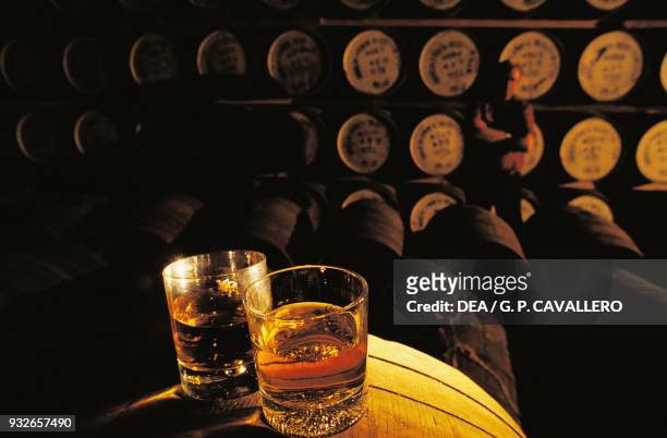 Whiskey glasses on a barrel in a whiskey distillery, Hebrides, United Kingdom.