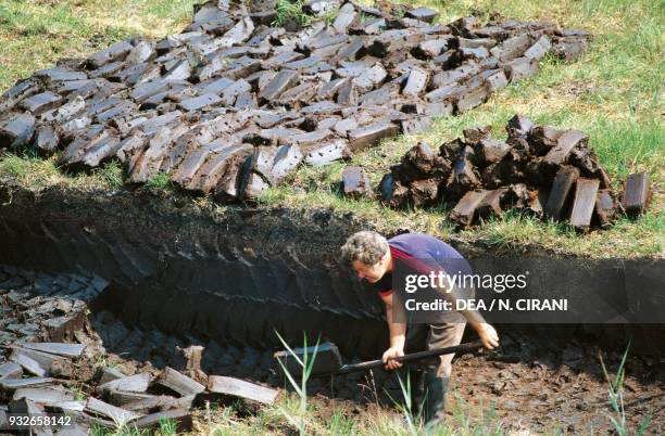 Farmer cutting peat turf, Recess, County Galway, Ireland.