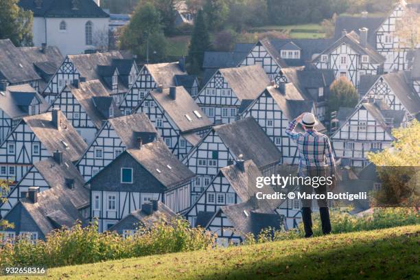 tourist looking at the timber-framed houses of freudenberg, germany. - einfamilienhaus stock-fotos und bilder