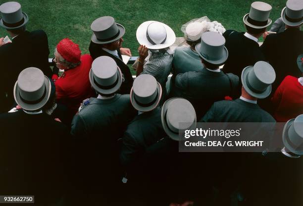 Men wearing top hats and women wearing hats at Ascot Racecourse, Ascot, United Kingdom.