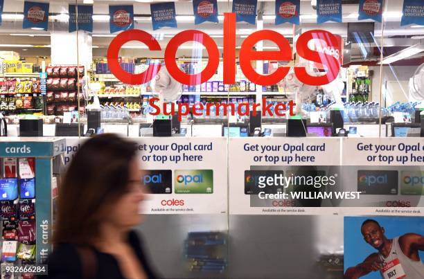 Woman walks past a Coles supermarket in Sydney's central business district on March 16, 2018. Australian supermarket chain Coles will be spun off...