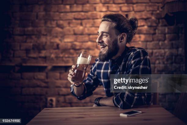 gelukkig man genieten in bier zittend in een bar. - man sipping beer smiling stockfoto's en -beelden
