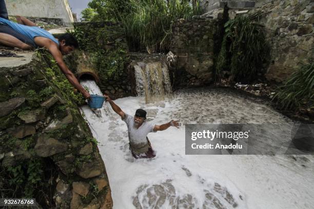 Resident tests the water content of Ph on a tributary stream filled with textile waste in Sukamaju Village, Majalaya, Bandung, West Java, Indonesia,...