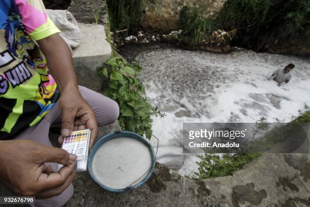 Member of the Environmental Lovers community tests the water content of Ph in the flow of tributaries filled with textile waste at Cikacembang River...