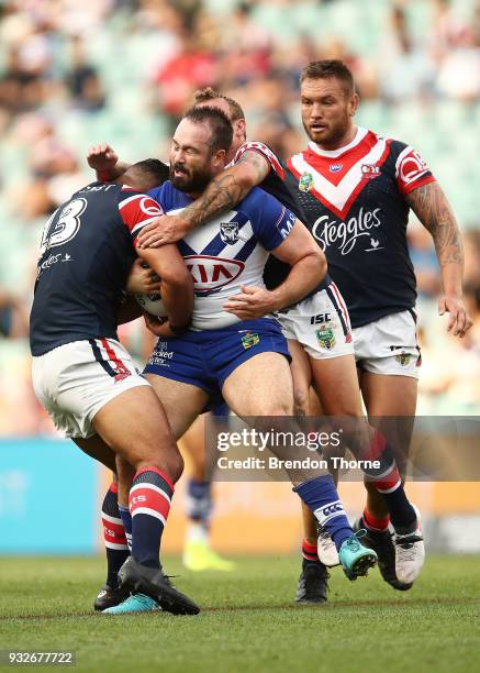 Aaron Woods of the Bulldogs is tackled by Roosters defence during the round two NRL match between the Sydney Roosters and the Canterbury Bulldogs at...