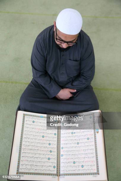 Imam reading the Quran in a mosque. France.