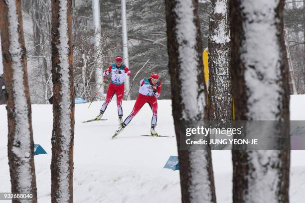 Emily Young of Canada and compatriot Brittany Hudak compete in the women's 12.5km standing biathlon event at the Alpensia Biathlon Centre during the...
