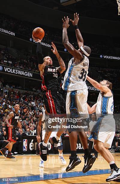 Michael Beasley of the Miami Heat shoots against Brendan Haywood and Fabricio Oberto of the Washington Wizards during the game at the Verizon Center...