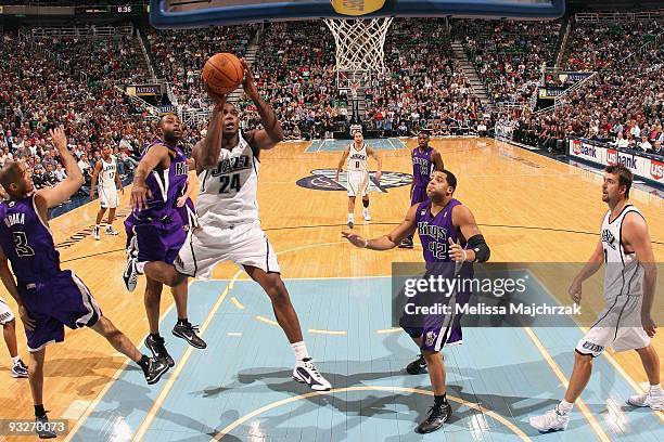 Paul Millsap of the Utah Jazz shoots against Kenny Thomas and Ime Udoka of the Sacramento Kings during the game at EnergySolutions Arena on November...