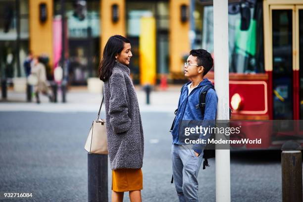 indonesian mother and her 12 years old son are talking on the street. - 12 13 years stock-fotos und bilder