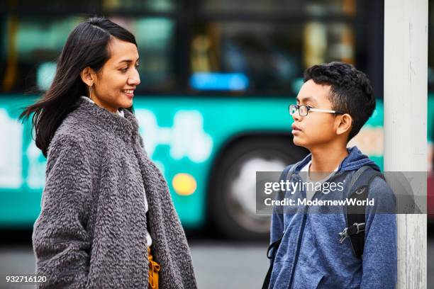 indonesian mother and her 12 years old son are talking on the street. - 12 13 years stock pictures, royalty-free photos & images