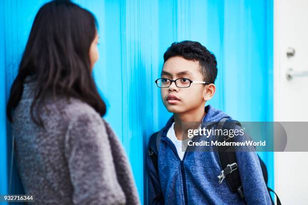 indonesian mother and her 12 years old son talking by the wall - 12 years stock-fotos und bilder