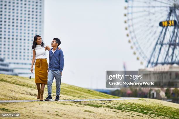 indonesian mother and her 12 years old son walking in the grass - 12 13 years photos photos et images de collection