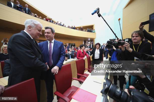 Markus Soeder of the Bavarian Christian Democrats arrives with German Interior Minister Horst Seehofer at the Bavarian state parliament on March 16,...