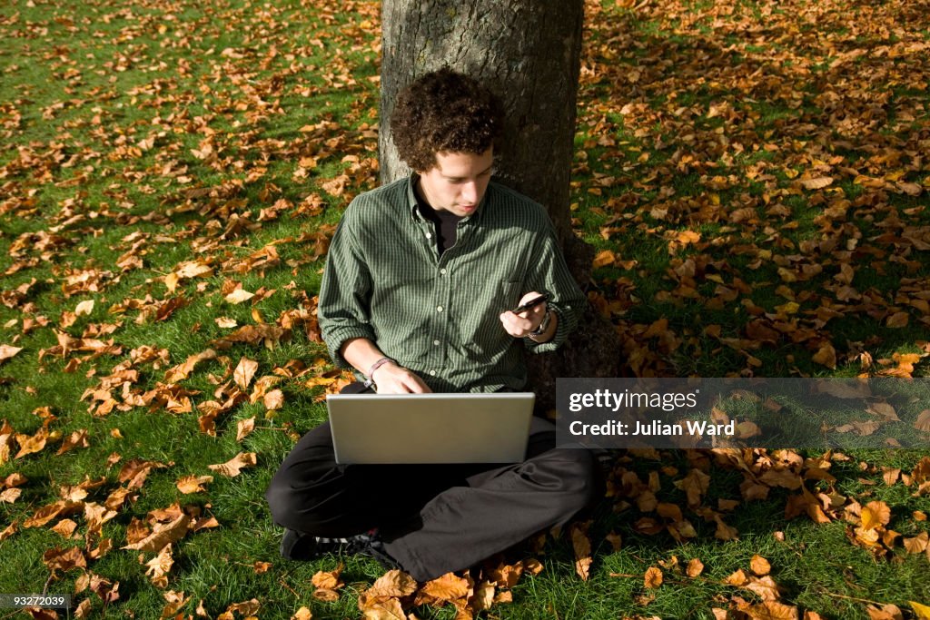 Man in a park with mobile technology